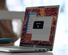 Laptop displaying a computer screen with a colorful abstract pattern on a blurred background